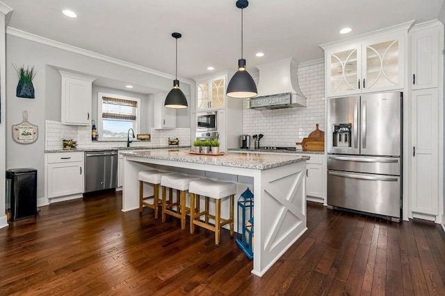 kitchen with premium range hood, glass insert cabinets, appliances with stainless steel finishes, and white cabinetry