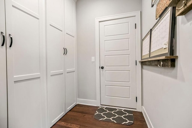 entryway featuring baseboards and dark wood-style floors