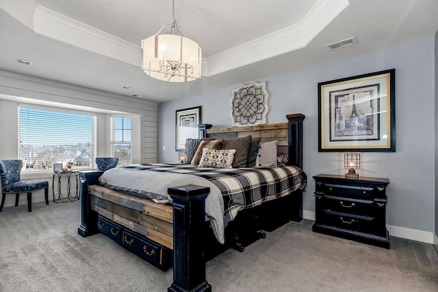 carpeted bedroom featuring a tray ceiling, baseboards, visible vents, and ornamental molding