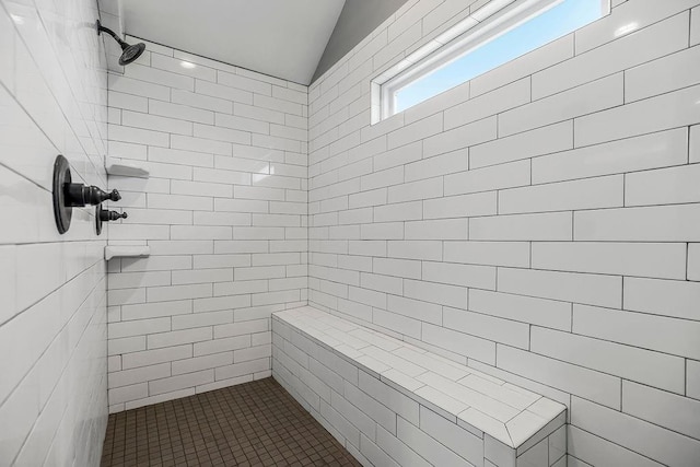 full bath with a tile shower and vaulted ceiling