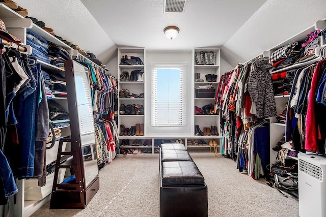 spacious closet featuring visible vents, carpet floors, and vaulted ceiling