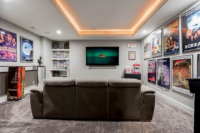 cinema room featuring carpet flooring, a raised ceiling, and visible vents