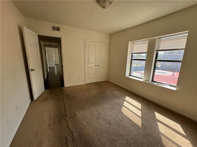 3112 Benton Blvd, Kansas City, MO 64128 - unfurnished bedroom with baseboards, carpet, visible vents, and a closet