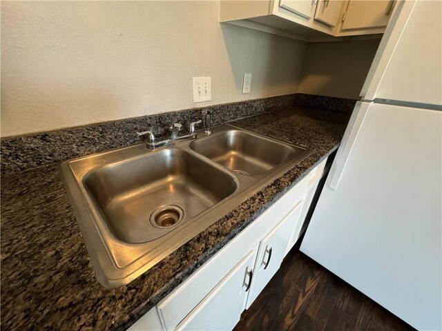 3112 Benton Blvd, Kansas City, MO 64128 - interior details featuring dark wood-type flooring, freestanding refrigerator, a sink, and dark countertops