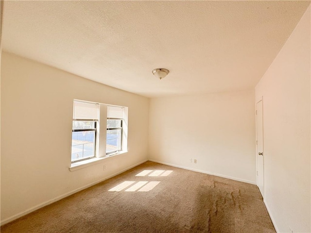 3112 Benton Blvd, Kansas City, MO 64128 - empty room with carpet floors, a textured ceiling, and baseboards