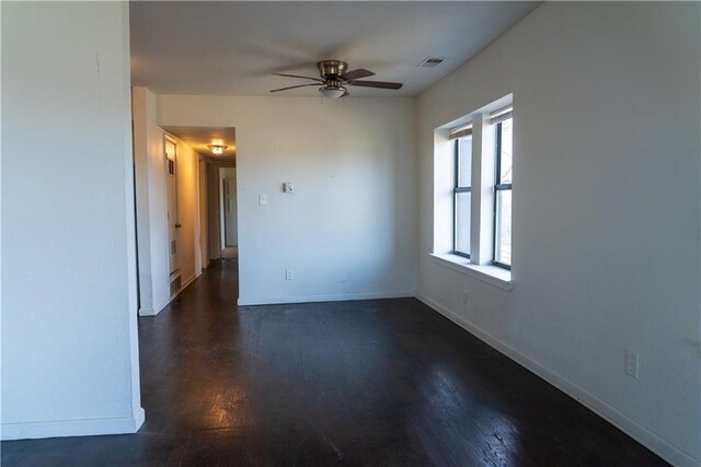 3112 Benton Blvd, Kansas City, MO 64128 - spare room featuring dark wood-style floors, visible vents, ceiling fan, and baseboards