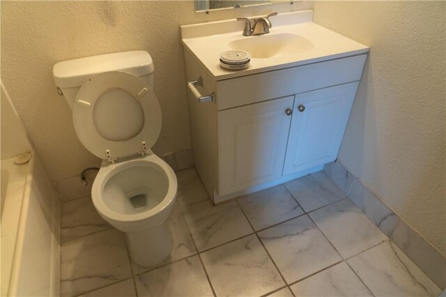 3112 Benton Blvd, Kansas City, MO 64128 - bathroom featuring a textured wall, marble finish floor, vanity, and toilet