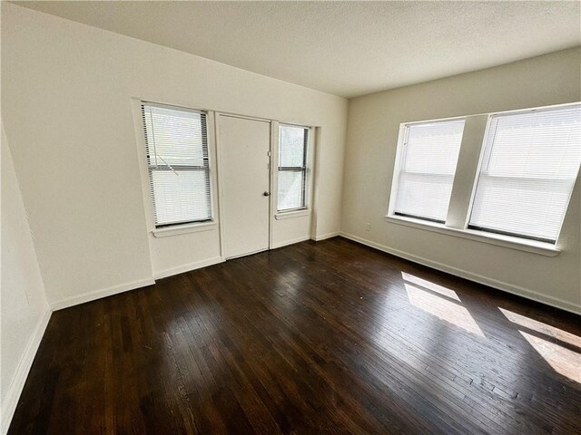 3112 Benton Blvd, Kansas City, MO 64128 - spare room with wood-type flooring, a textured ceiling, and baseboards