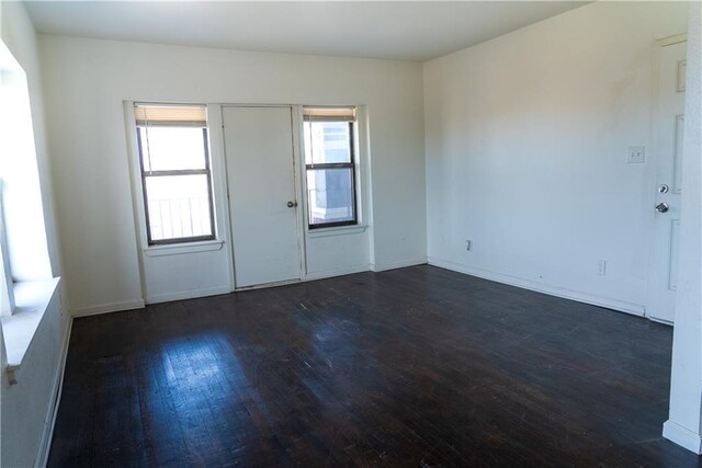 3112 Benton Blvd, Kansas City, MO 64128 - empty room featuring dark wood-style flooring and baseboards
