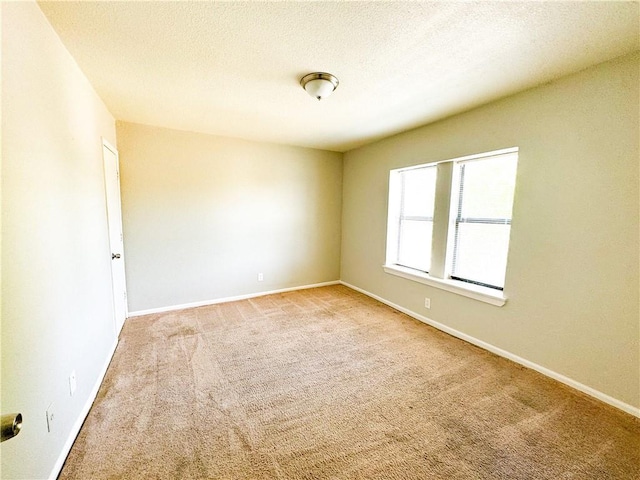 3112 Benton Blvd, Kansas City, MO 64128 - spare room featuring carpet flooring, a textured ceiling, and baseboards