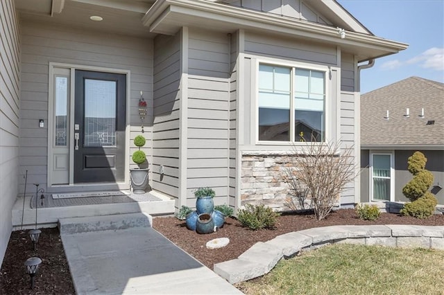 property entrance featuring stone siding and board and batten siding