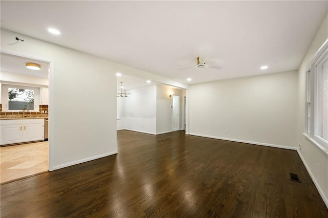 empty room with recessed lighting, wood finished floors, visible vents, and baseboards