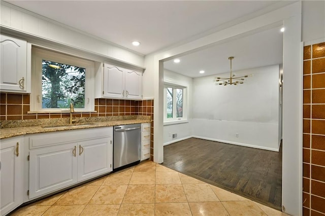 kitchen featuring white cabinets, dishwasher, backsplash, a sink, and light tile patterned flooring