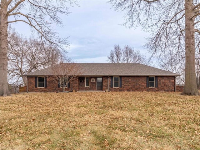 ranch-style home featuring brick siding and roof with shingles