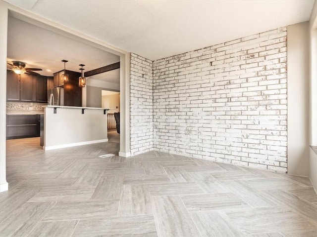 empty room featuring brick wall and ceiling fan