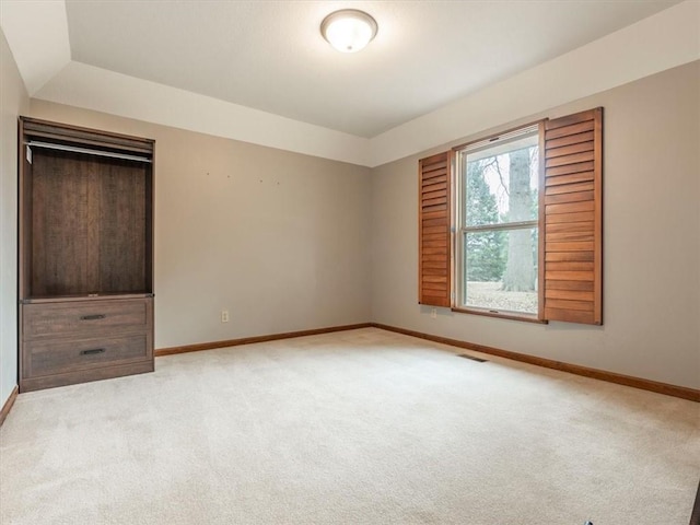 unfurnished bedroom featuring light carpet, visible vents, and baseboards