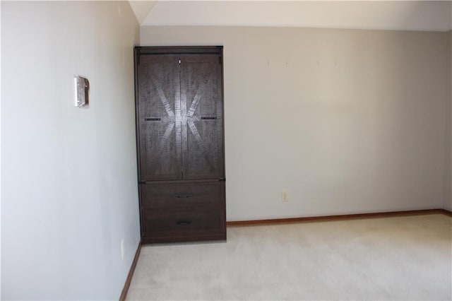 unfurnished bedroom featuring light carpet and baseboards