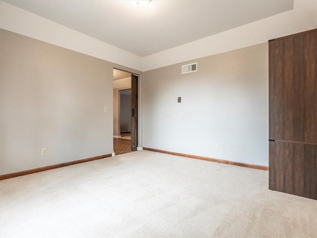 carpeted empty room featuring visible vents and baseboards