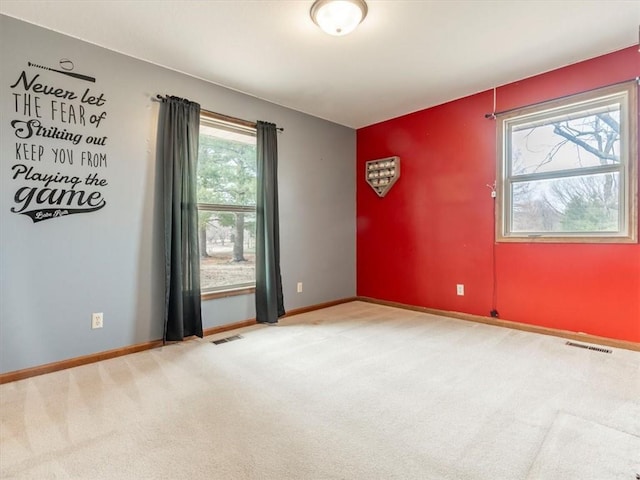 empty room featuring carpet flooring, baseboards, and visible vents