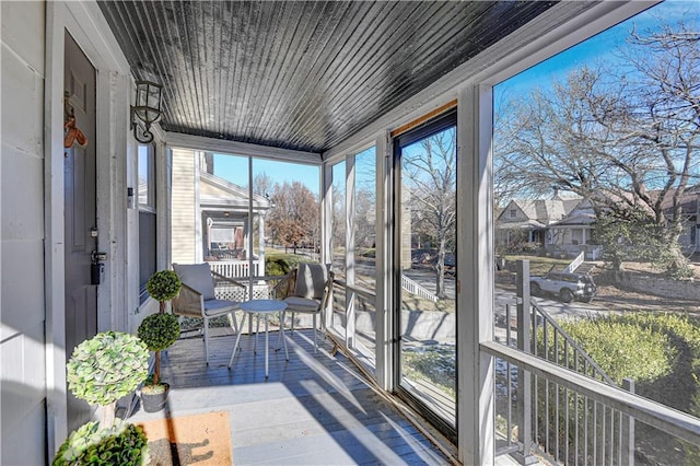 sunroom / solarium featuring wood ceiling and a healthy amount of sunlight