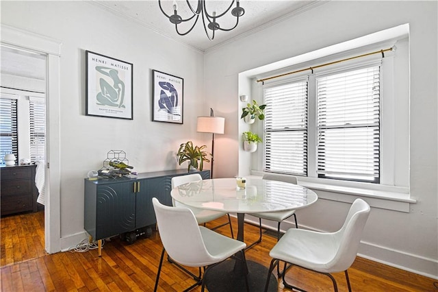 dining space featuring a healthy amount of sunlight, wood-type flooring, baseboards, and ornamental molding