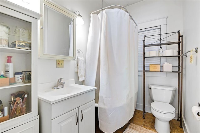 bathroom with vanity, curtained shower, and toilet