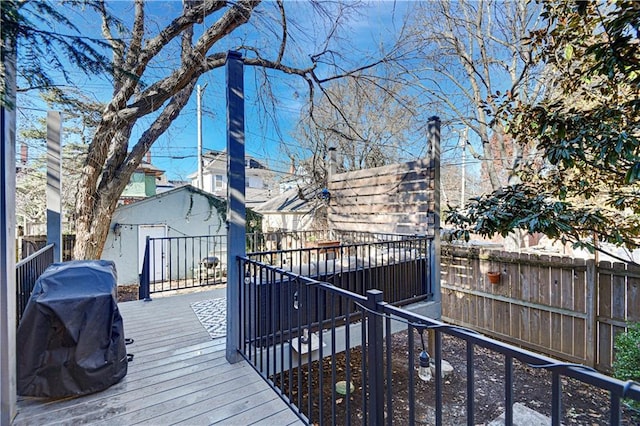 wooden terrace with an outdoor structure and fence