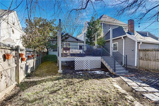 rear view of house featuring a deck and a fenced backyard