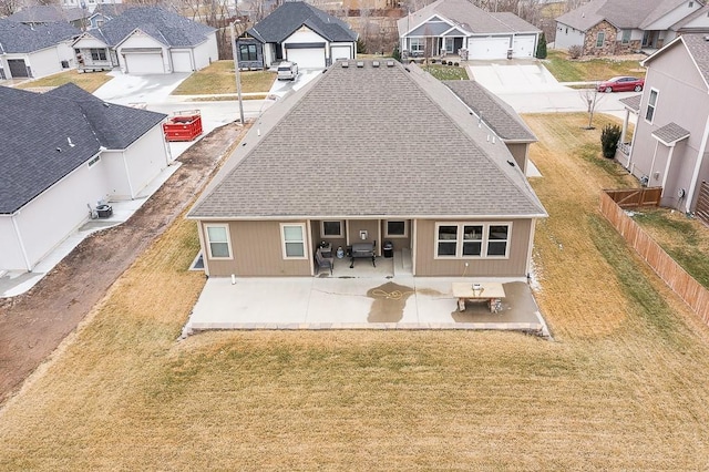 back of property with roof with shingles, a residential view, fence, and a patio