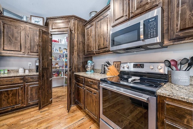 kitchen with stainless steel appliances and dark brown cabinetry