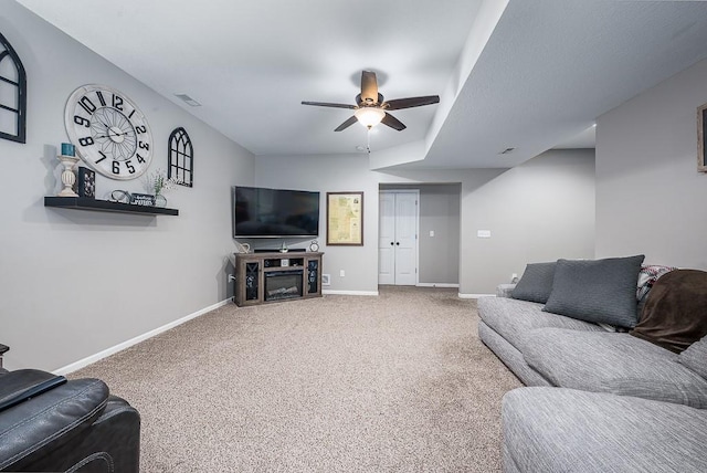 living area with ceiling fan, carpet, a fireplace, and baseboards