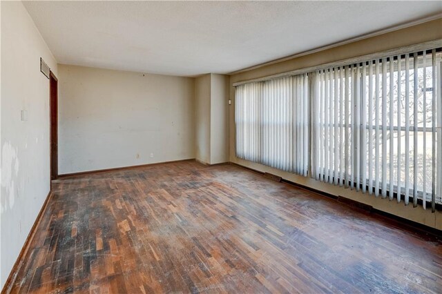 spare room with visible vents, baseboards, and wood finished floors