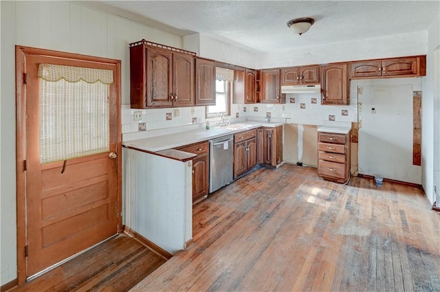 kitchen featuring backsplash, wood-type flooring, and stainless steel dishwasher