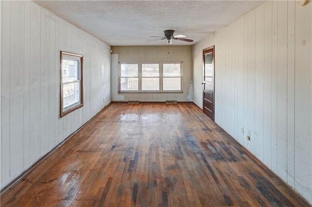 spare room with hardwood / wood-style floors, a ceiling fan, and a textured ceiling