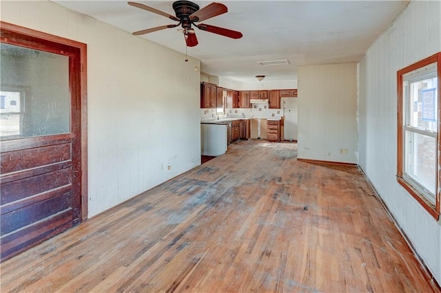 unfurnished living room with light wood-style floors, visible vents, and ceiling fan