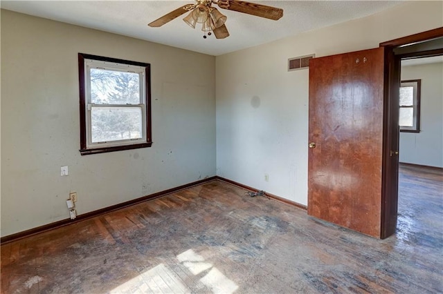 unfurnished bedroom with visible vents, multiple windows, and baseboards