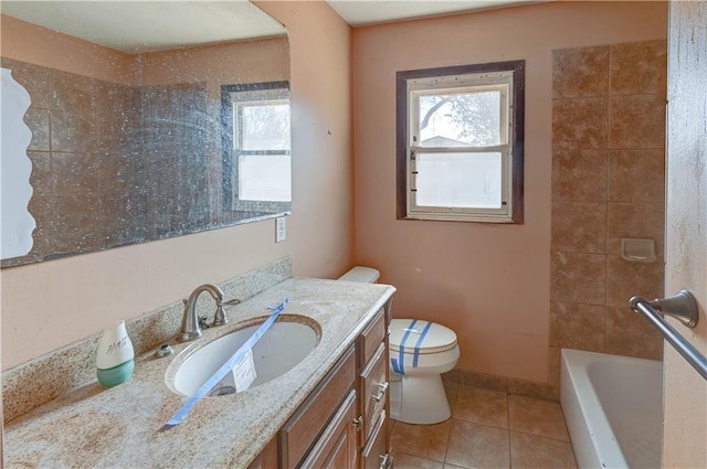 bathroom featuring tile patterned floors, toilet, a healthy amount of sunlight, and a bath