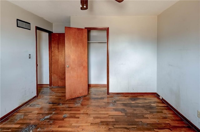 unfurnished bedroom featuring a closet, a ceiling fan, baseboards, and hardwood / wood-style floors