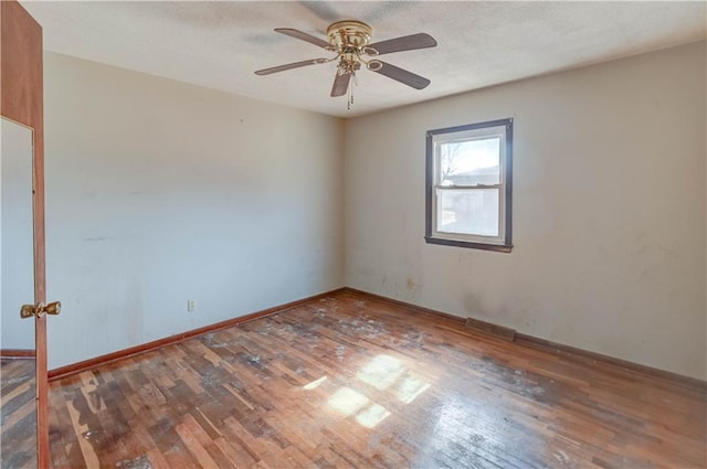 unfurnished room featuring baseboards, a textured ceiling, a ceiling fan, and wood finished floors