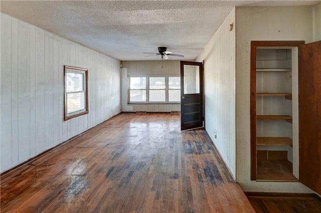 spare room with a textured ceiling, a ceiling fan, and hardwood / wood-style floors