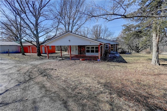 view of front facade featuring a carport, covered porch, and a front yard