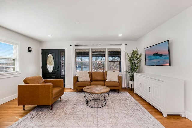 living area with recessed lighting, baseboards, and light wood-type flooring