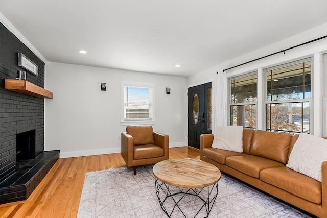 living area with a brick fireplace, recessed lighting, wood finished floors, and baseboards