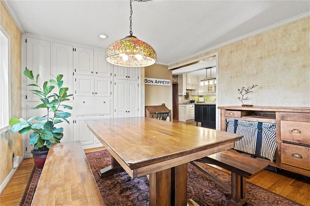 dining space with light wood-type flooring, baseboards, and ornamental molding