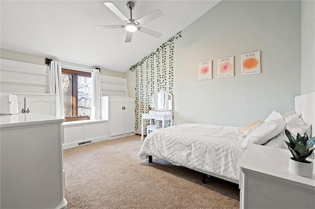 carpeted bedroom with visible vents, a textured ceiling, lofted ceiling, and a ceiling fan