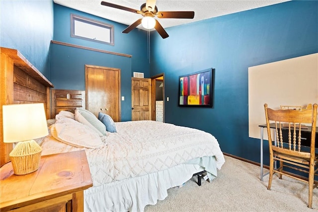 bedroom featuring carpet, a closet, a towering ceiling, and ceiling fan