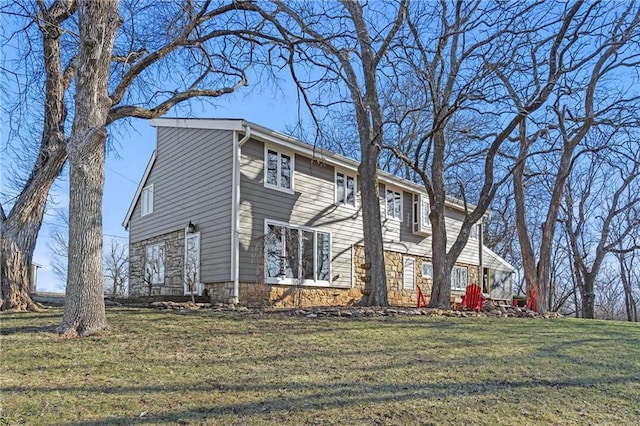 view of property exterior featuring stone siding and a lawn