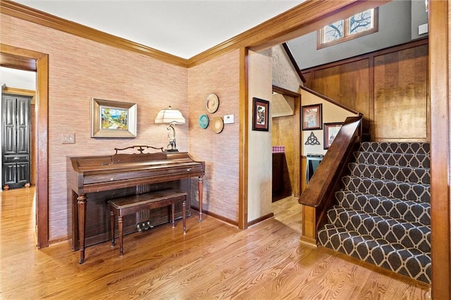 stairway with vaulted ceiling, ornamental molding, and wood finished floors