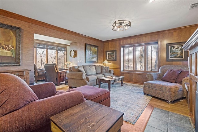 living area featuring visible vents and ornamental molding