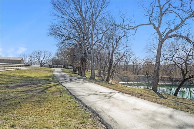 view of road featuring aphalt driveway and a water view